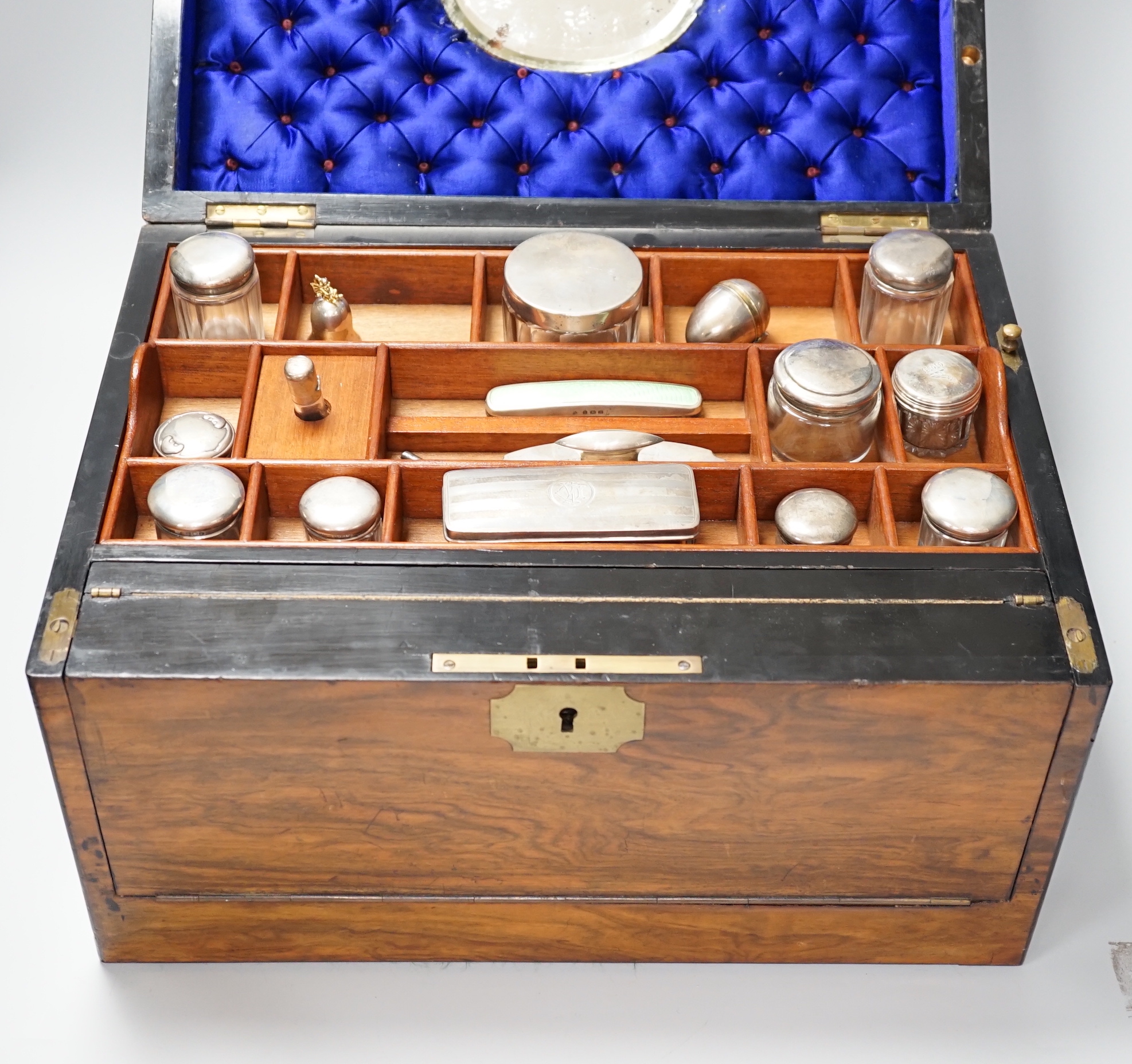 A Victorian combination walnut writing and toilet box, containing various silver lidded glass jars, inset bevelled mirror and other accessories, 40.5cm x 28.5cm x 24.5cm